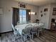 Inviting dining room with a classic chandelier and a long table set for Gathering meals, adjacent to a window at 1439 Silver Pine Ln, Sheridan, IN 46069