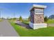 Stone community entrance sign set amongst beautiful landscaping with lush green lawns and verdant trees at 15946 Meadow Frost Ct, Fishers, IN 46037