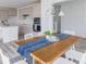Dining area with wood table, white chairs, and open view into the modern kitchen at 15946 Meadow Frost Ct, Fishers, IN 46037