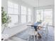 Bright dining room with large windows, modern chandelier, wood table, and white chairs at 15946 Meadow Frost Ct, Fishers, IN 46037