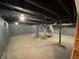 Spacious unfinished basement featuring exposed ceiling beams, concrete floor, and utility access for customization at 1649 N Arsenal Ave, Indianapolis, IN 46218