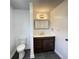 Bathroom with dark wood cabinets, white countertop, gold faucet and modern lighting at 1649 N Arsenal Ave, Indianapolis, IN 46218