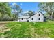 Rear of a white home with a chimney, surrounded by trees and well-manicured grass at 1805 Center Valley Rd, Martinsville, IN 46151