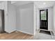 Bright entryway featuring light gray walls, wood-look floors, and a modern black front door at 1805 Center Valley Rd, Martinsville, IN 46151