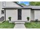 Charming entryway with modern black door, freshly painted white brick, and professional landscaping at 1805 Center Valley Rd, Martinsville, IN 46151
