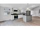 Bright kitchen featuring white cabinets, stainless appliances, a center island, and wood-look floors at 1805 Center Valley Rd, Martinsville, IN 46151