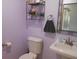 Cozy half bathroom with lavender walls, a pedestal sink, and decorative wall shelving at 2020 N Hickory Blvd, Greenfield, IN 46140