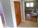 Hallway with gray walls and tiled floors leading to a living room with hardwood floors at 2020 N Hickory Blvd, Greenfield, IN 46140