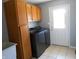 Spacious laundry room features a modern washer and dryer set, storage cabinets, and tile floors at 2020 N Hickory Blvd, Greenfield, IN 46140