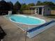 Kidney-shaped in-ground pool with cover and white shed, surrounded by concrete slab at 2020 N Hickory Blvd, Greenfield, IN 46140