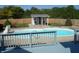 Backyard in-ground pool with painted wood deck, basketball hoop, white shed and manicured lawn at 2020 N Hickory Blvd, Greenfield, IN 46140