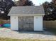Rustic white shed with crossbuck doors and a gray shingled roof sits on a gravel pad at 2020 N Hickory Blvd, Greenfield, IN 46140