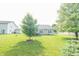 Expansive backyard with lush green grass and mature trees surrounding the property at 2402 Foxtail Dr, Plainfield, IN 46168