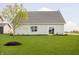 Well-maintained backyard with lush green grass, a young tree, and a patio sliding door at 278 Evening Bay Ct, Pendleton, IN 46064