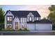 New two-story home design with brick, three-car garage, black roof, flower bed, and manicured lawn at 3638 Sycamore Bend N Way, Columbus, IN 47203