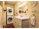 Well-lit bathroom featuring modern vanity with sink and stacked washer and dryer at 3959 Central Ave, Indianapolis, IN 46205