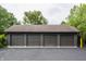 Spacious four-car garage with gray doors and black asphalt driveway offering ample parking and storage at 3959 Central Ave, Indianapolis, IN 46205