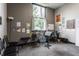 Small studio space featuring carpeted flooring, a window overlooking the outdoors, and an array of posted artwork at 3959 Central Ave, Indianapolis, IN 46205