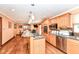 Open kitchen with granite countertops, stainless steel appliances, and wood floors offers modern convenience at 4080 Wander Way, Greenwood, IN 46142