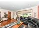 Inviting living room with a black leather sectional, hardwood floors, and a view to the front yard at 4080 Wander Way, Greenwood, IN 46142