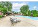 Backyard pool featuring an outdoor fireplace, gazebo, lush trees, and patio furniture at 4080 Wander Way, Greenwood, IN 46142