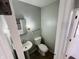 Cozy half bathroom featuring a pedestal sink, toilet, and framed mirror for added convenience at 4408 Clovelly Ct, Indianapolis, IN 46254