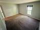 A carpeted bedroom offers a blank canvas with neutral walls, a large window, and ample natural light at 4408 Clovelly Ct, Indianapolis, IN 46254