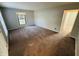 A carpeted bedroom offers a blank canvas with neutral walls, a large window, and ample natural light at 4408 Clovelly Ct, Indianapolis, IN 46254
