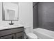Modern bathroom with gray vanity and stylish gray subway tile in shower and a large mirror at 443 Flora Pl, Carmel, IN 46290