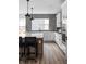 Modern kitchen with white cabinets, gray backsplash, stainless steel appliances, and a quartz countertop island at 443 Flora Pl, Carmel, IN 46290