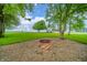 A cozy backyard with a brick fire pit, perfect for entertaining and enjoying the outdoors. Mature trees surround the property at 4491 W 600 N, Anderson, IN 46011
