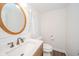 Well-lit bathroom with wood-look vinyl floor, round mirror, shiplap walls, and modern fixtures at 4491 W 600 N, Anderson, IN 46011
