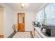 Hallway nook with natural light, built-in beverage center, wood-look vinyl floor, and nearby bathroom at 4491 W 600 N, Anderson, IN 46011
