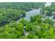 Overhead view of a wooded neighborhood, showcasing a lake, bridge, and scattered homes at 460 W Hinshaw Dr, Nineveh, IN 46164
