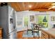 The dining area features wood floors, a wood ceiling, and an adjacent stainless steel refrigerator at 460 W Hinshaw Dr, Nineveh, IN 46164