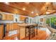 Bright kitchen with wooden ceilings, an island with seating, stainless steel appliances, and hardwood floors at 460 W Hinshaw Dr, Nineveh, IN 46164