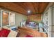 Sunroom with wooden ceiling, playset and a view of the wooded property at 460 W Hinshaw Dr, Nineveh, IN 46164