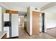 Hallway showing multiple rooms and white refrigerator with black accents and matching cabinetry at 4749 Rocky Knob Ln, Indianapolis, IN 46254