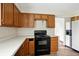 Bright kitchen featuring wooden cabinets, laminate countertops, and black range oven appliance at 4749 Rocky Knob Ln, Indianapolis, IN 46254