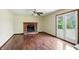 Living room with hardwood floors, ceiling fan, brick fireplace, and a doorway leading outside at 4749 Rocky Knob Ln, Indianapolis, IN 46254