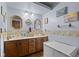 Bathroom with a double sink vanity, seashell wallpaper, and decorative mirrors reflecting beach themed artwork at 476 Turnberry Ct, Avon, IN 46123