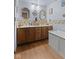 Bathroom with double sink vanity, seashell themed wallpaper, and hardwood floors, next to storage bin at 476 Turnberry Ct, Avon, IN 46123