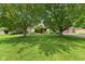 Spacious front yard with mature trees providing ample shade and a well-maintained lawn at 476 Turnberry Ct, Avon, IN 46123
