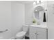 Bright bathroom featuring modern vanity, stylish round mirror, and white toilet at 4836 Winthrop Ave, Indianapolis, IN 46205