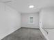 Clean, empty bedroom features neutral carpeting, a window, and a white door with a blank canvas at 4836 Winthrop Ave, Indianapolis, IN 46205