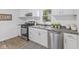 Well-lit kitchen equipped with modern appliances, white cabinetry, and hardwood floors at 4836 Winthrop Ave, Indianapolis, IN 46205