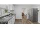 Modern kitchen with stainless steel appliances, hardwood floors, and a view into the adjacent dining area at 4836 Winthrop Ave, Indianapolis, IN 46205
