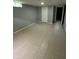 Finished basement featuring tiled floors, paneled walls, and a white door with light coming from the stairs at 4908 Elmhurst Dr, Indianapolis, IN 46226