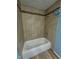 Bathroom area featuring tile in the shower and bath area with a small accent row of decorative tile at 4908 Elmhurst Dr, Indianapolis, IN 46226