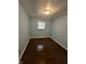 Clean bedroom with gleaming hardwood floors and a bright window for natural light at 4908 Elmhurst Dr, Indianapolis, IN 46226